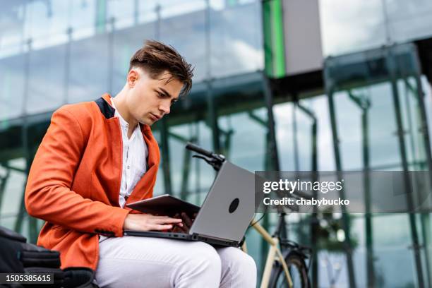 busy young man using digital tablet and laptop in same time - time life authors stock pictures, royalty-free photos & images