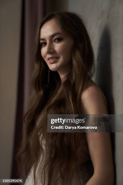 beautiful young woman with long brown hair in wedding dress on grey background with copy space. the happy woman is smiling. - wavy hair ストックフォトと画像