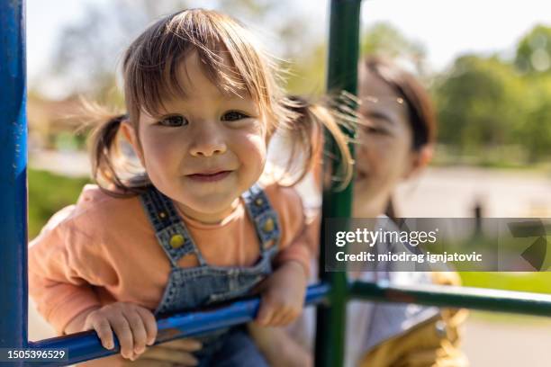 portrait of little girl on a jungle gym with her mother - yngre skolåldern bildbanksfoton och bilder