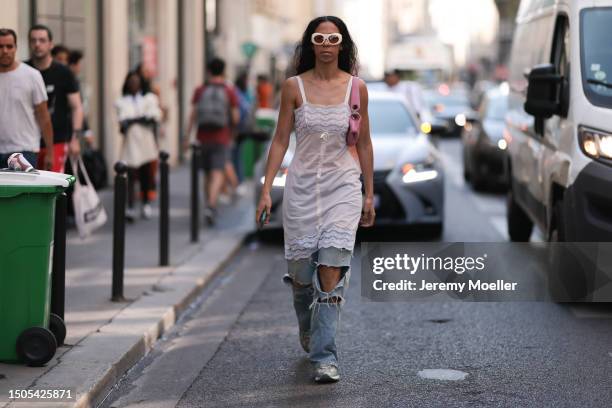 Guest seen is wearing sunglasses, a white strap dress with lace applications around the chest and lace applications on the hem combined with a loose...