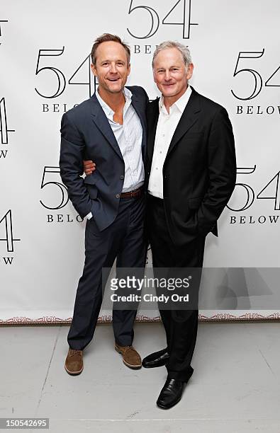Actor John Benjamin Hickey poses with actor Victor Garber backstage following his performance at 54 Below on August 20, 2012 in New York City.