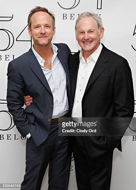 Actor John Benjamin Hickey poses with actor Victor Garber backstage following his performance at 54 Below on August 20, 2012 in New York City.