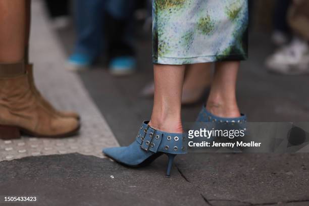 Guest is seen wearing a colorful tight-fitting dress with ankle length in turquoise, black, dark blue and orange combined with blue heels with a...