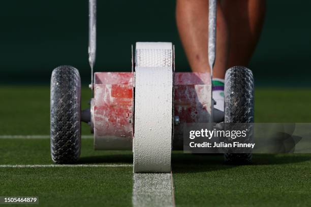 Member of ground staff paints the lines on the court ahead of The Championships - Wimbledon 2023 at All England Lawn Tennis and Croquet Club on June...