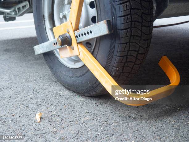 vehicle wheel with a clamp to immobilize it. germany. - sabot de denver photos et images de collection