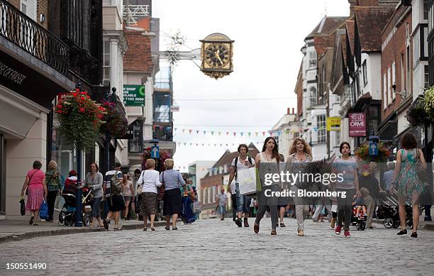 Pedestrians pass stores on the High Street in Guildford, U.K., on Tuesday, Aug. 21, 2012. U.K. Retail sales unexpectedly rose in July as promotions...