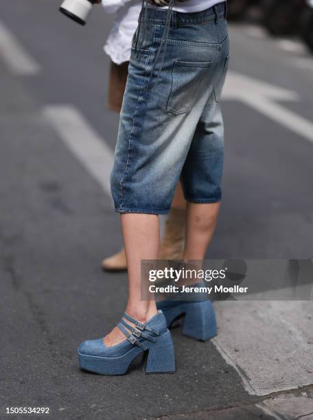 Svita Sobol is wearing an oversized knee length Botter jeans and blue plateau pumps outside Botter show during the Menswear Spring/Summer 2024 as...