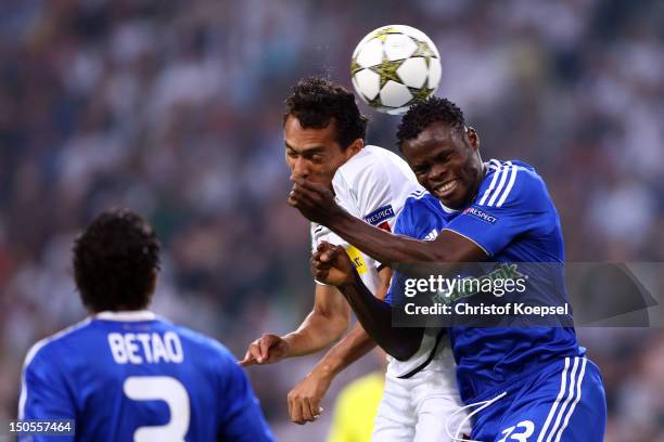 Igor de Camargo of Moenchengladbach and Taye Taiwo of Kiew go up for a header during the UEFA Champions League play-off first leg match between...