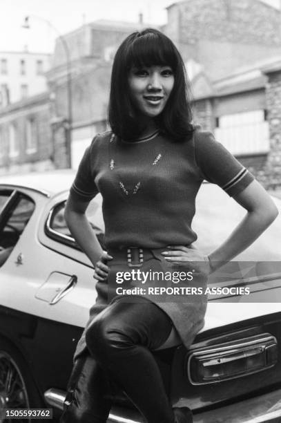La romancière vietnamienne Mei Chen Chalais assise sur une voiture ancienne à Paris le 10 novembre 1967