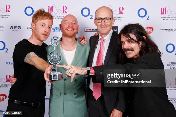 James Johnston, Peter Leathem, Simon Neil and Ben Johnston pose in the winners room with the award for Best Live Act during the Nordoff and Robbins...