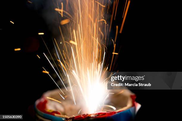 vibrant sparkler exploding against a black background - funkenflug stock-fotos und bilder