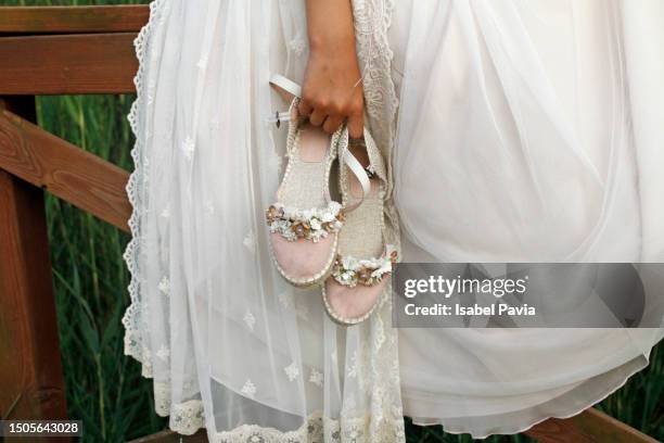 close-up of girl holding communion shoes - wedding shoes fotografías e imágenes de stock