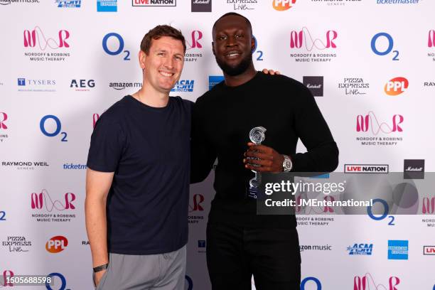 Representative from O2 and Stormzy pose in the winners room with the Flagship O2 Silver Clef Award during the Nordoff and Robbins O2 Silver Clef...