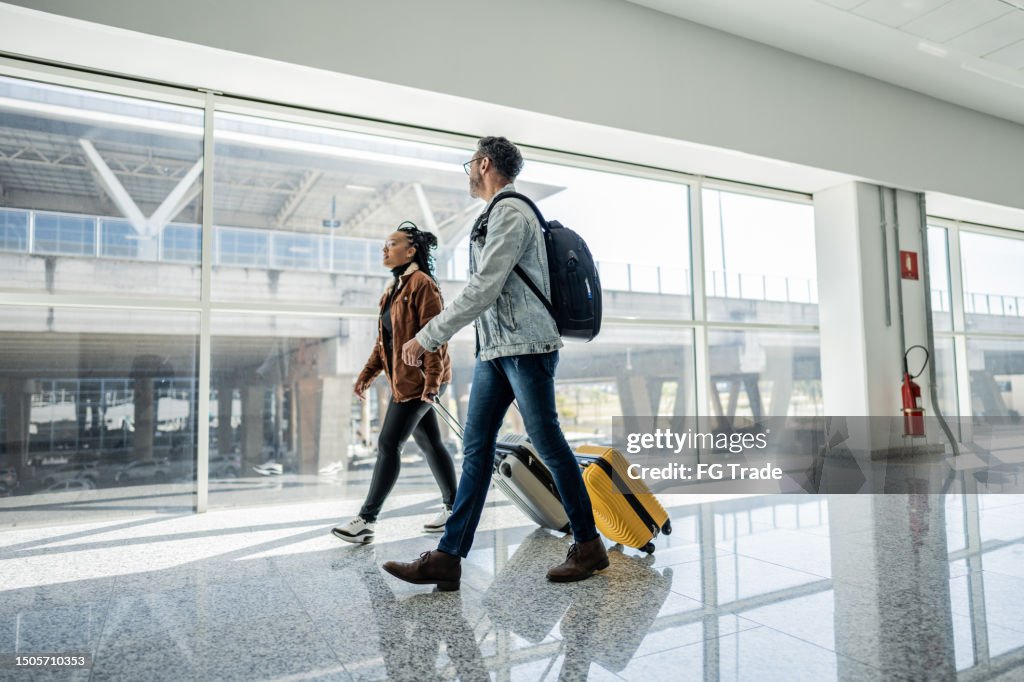 Amigos andando e conversando no aeroporto