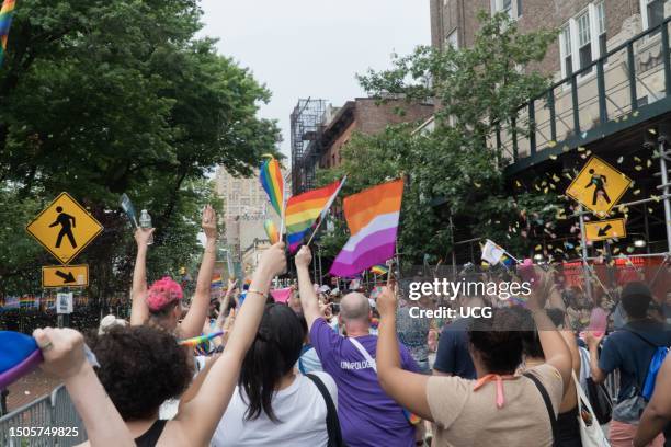 Jam-packed crowd reacts exuberantly in a flurry of colorful confetti launched by "celebration cannons" on Christopher Street in Manhattan, during NYC...