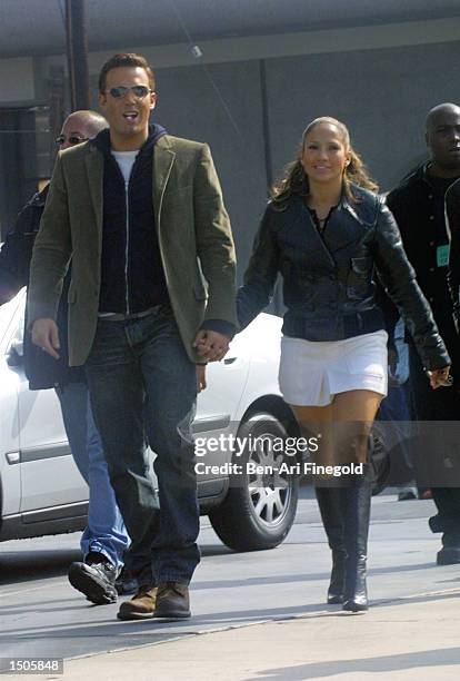 Actress/singer Jennifer Lopez and actor Ben Affleck hold hands while filming her new music video at Barefoot restaurant on October 20, 2002 in...