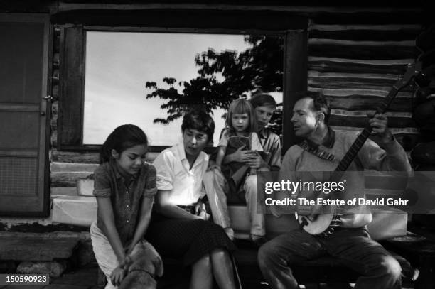 Folk musician Pete Seeger poses for a portrait with his family at their log cabin home in August, 1958 in Beacon, New York.