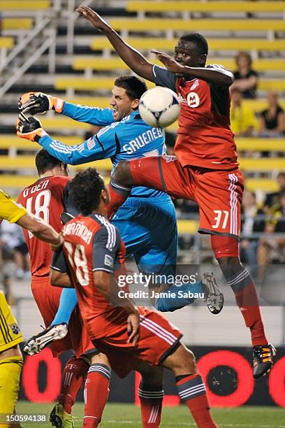 Goalkeeper Andy Gruenebaum of the Columbus Crew and Dicoy Williams of Toronto FC battle for control of the ball near the net in the second half on...