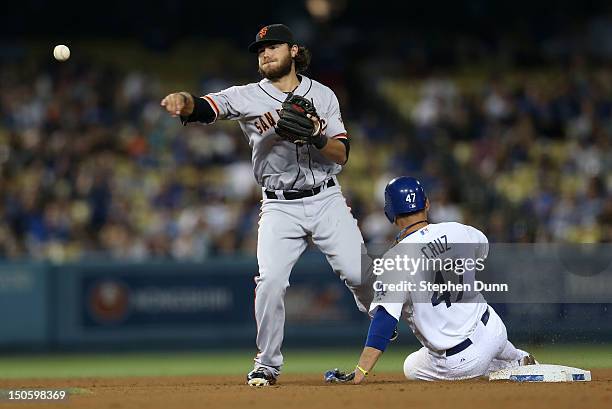 Shortstop Brandon Crawford of the San Francisco Giants throws to first after forcing out Luis Cruz of the Los Angeles Dodgers to complete a double...