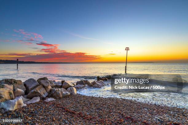 scenic view of sea against sky during sunset,mudeford,christchurch,united kingdom,uk - isle of wight stock-fotos und bilder