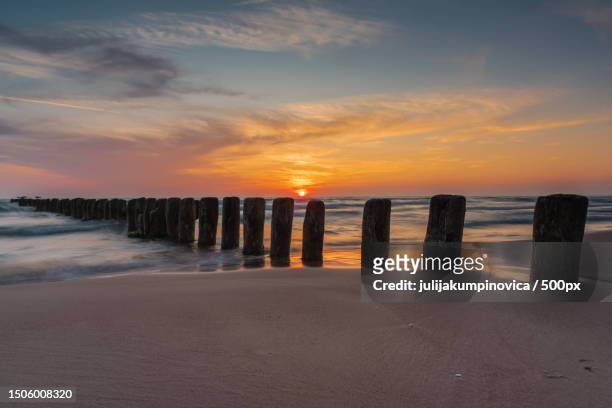 scenic view of sea against sky during sunset,latvia - groyne stock-fotos und bilder