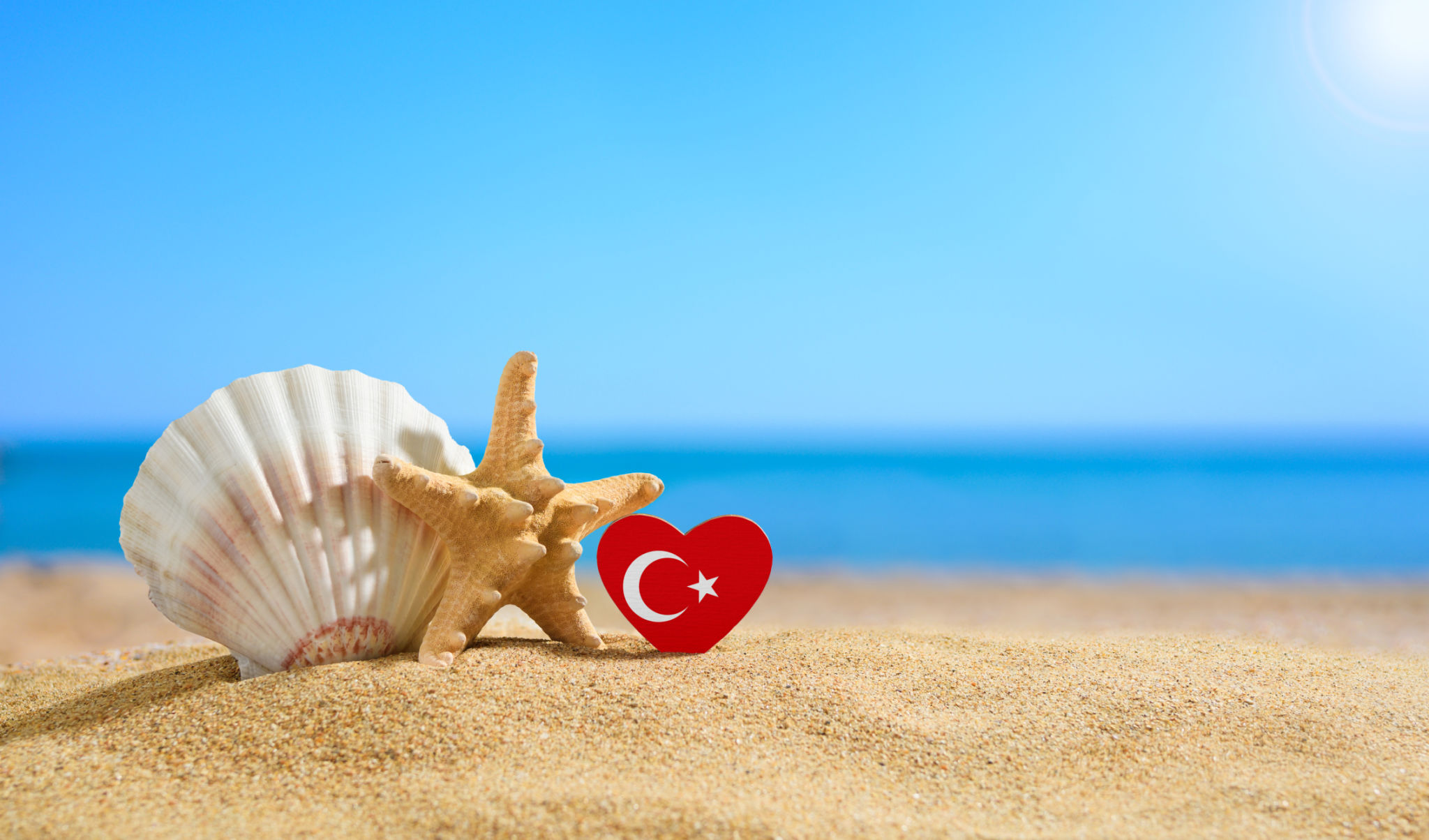 Beautiful beach in Turkey. Flag of Turkey in the shape of a heart and shells on a sandy beach. Beautiful beach in Turkey. Flag of Turkey in the shape of a heart and shells on a sandy beach.