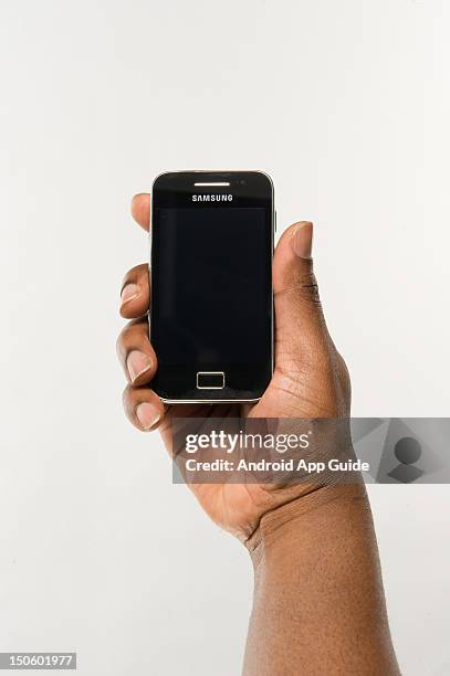 Man's hand holding a Samsung Galaxy Ace smartphone, during a studio shoot for Android App Guide, February 11, 2011.