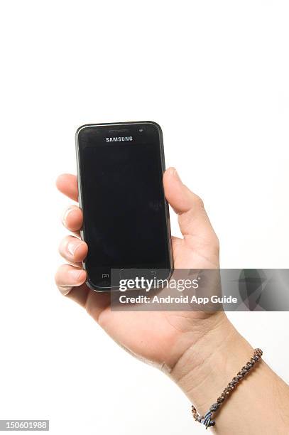 Man's hand holding a Samsung Galaxy S smartphone, during a studio shoot for Android App Guide, February 11, 2011.