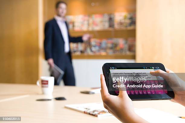 View of a man's hands as he uses a Samsung Galaxy Tab tablet computer in a meeting, during a shoot for Android App Guide, June 15 London.