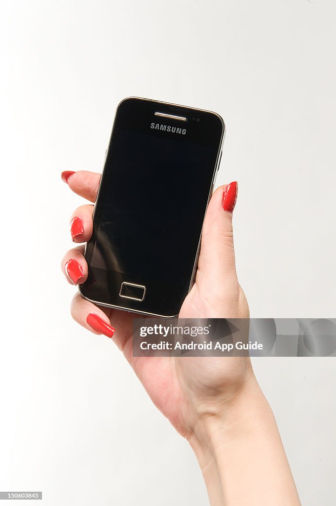 Pretty Android Hand A woman's hand holding a Samsung Galaxy Ace smartphone, during a ...