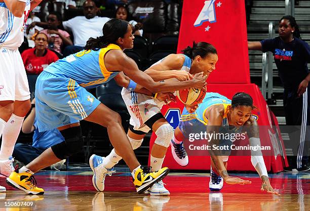 Armintie Price of the Atlanta Dream battles for a loose ball against Swin Cash and Tamera Young of the Chicago Sky at Philips Arena on August 22,...