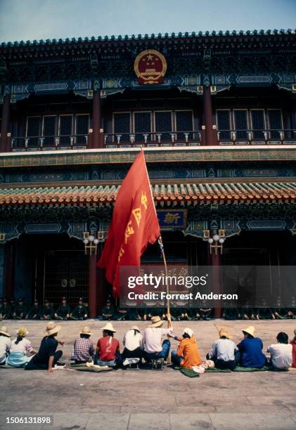 View of protesters sitting on the ground, facing seated Chinese Army soldiers, outside Zhongnahai Communist Party Headquarters during a pro-democracy...