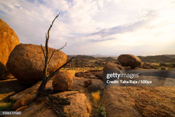 scenic view of rocks on field against sky,namibia - saillie rocheuse photos et images de collection