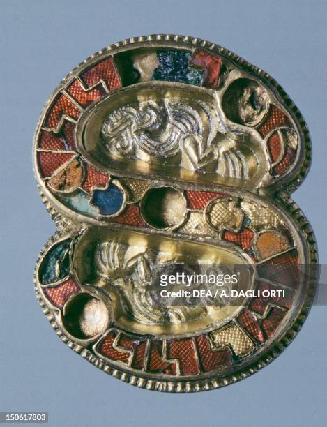 7th century S-shaped gilt silver fibula, embellished with gemstones and enamels. Goldsmith's art, Longobard civilization.