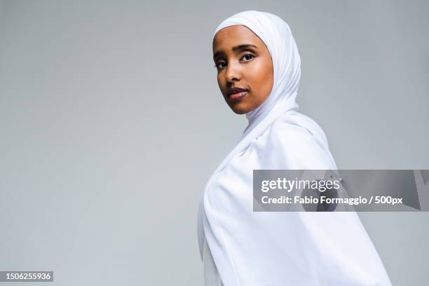 beautiful arab middle-eastern woman with traditional abaya in studio against white background,united arab emirates - emirati face smile fotografías e imágenes de stock