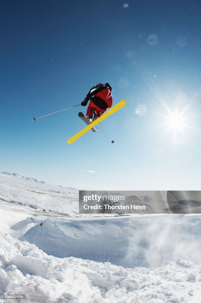 Skier jumping off snowy slope