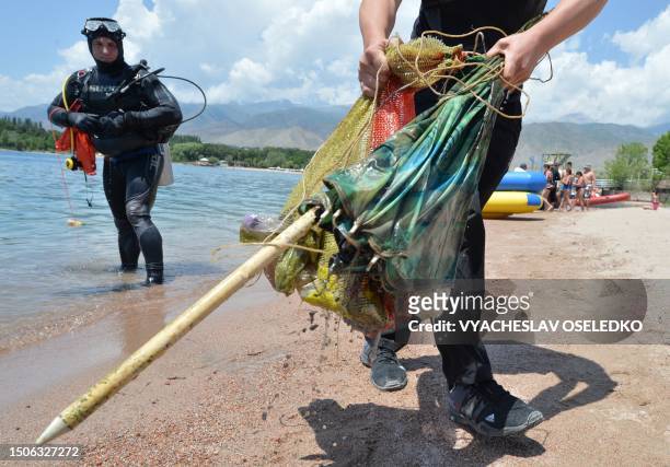 Group of volunteer divers works to collect waste from the bed of Lake Issyk Kul in Cholpon-Ata, some 250 km from Bishkek, on June 27, 2023. On the...