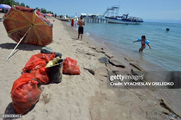 Sacks with waste items collected by a group of volunteer divers from the bed of Lake Issyk Kul are seen on a beach in Cholpon-Ata, some 250 km from...