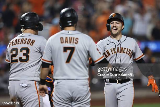 Patrick Bailey is greeted by teammates Joc Pederson and J.D. Davis of the San Francisco Giants after hitting a three-run home run during the eighth...