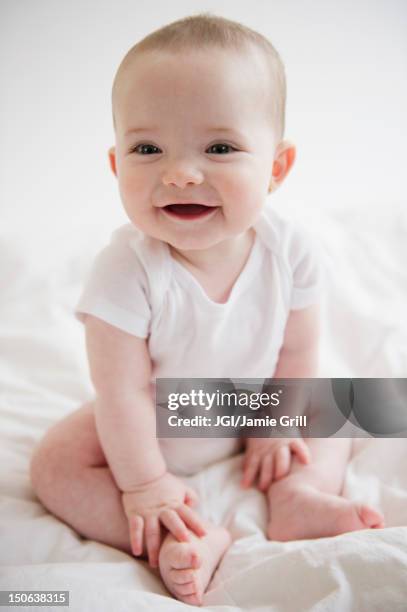 caucasian baby girl sitting on floor - infant bodysuit stock pictures, royalty-free photos & images