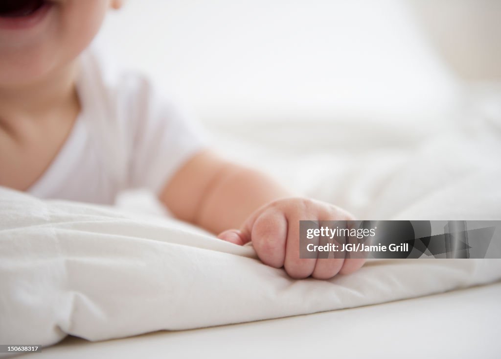 Mixed race baby boy laying on floor