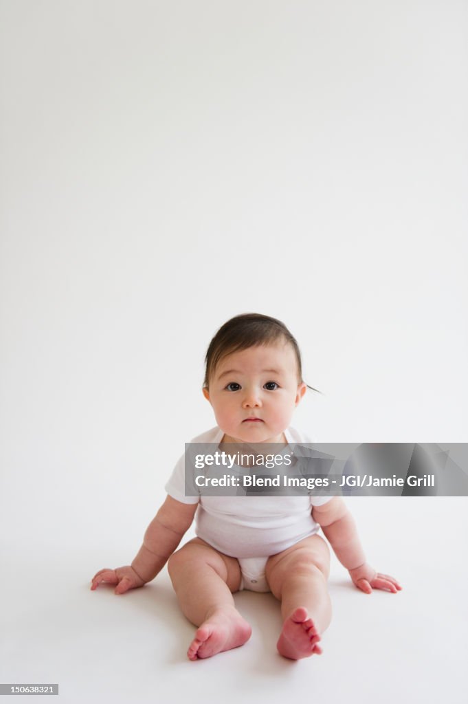 Asian baby girl sitting on floor