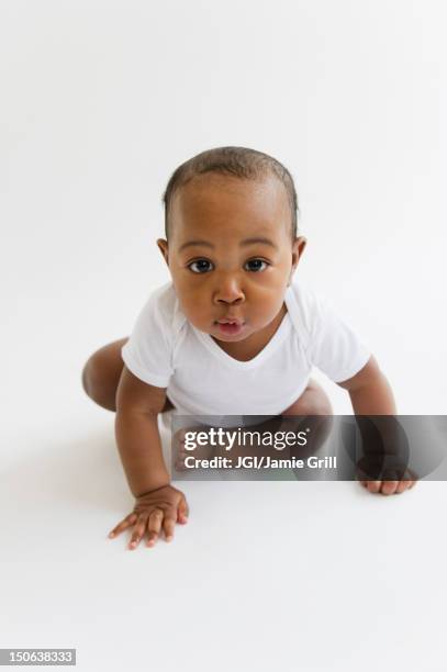 black baby boy crawling on floor - baby studio stock-fotos und bilder