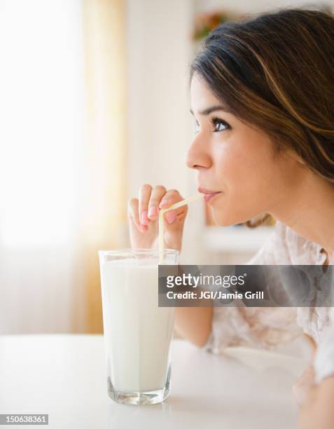 hispanic woman drinking milk through straw - drinking straw photos et images de collection