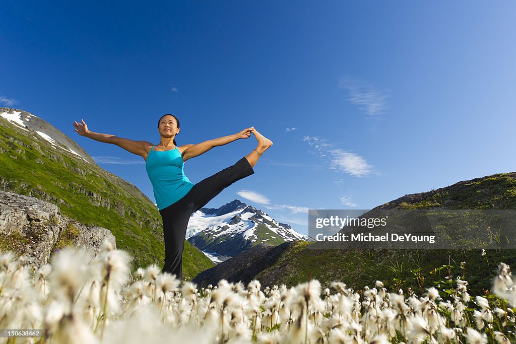 Korean woman practicing yoga with mountain in background