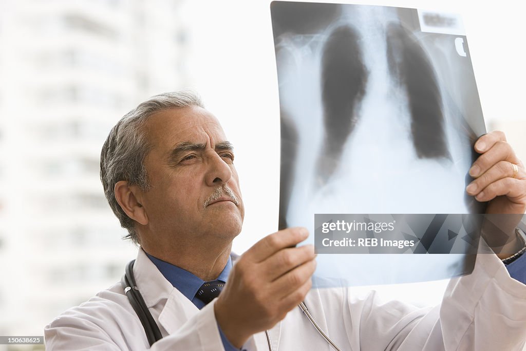 Hispanic doctor looking at x-ray