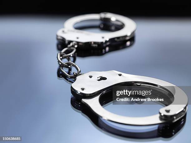 close up of metal handcuffs - crime or recreational drug or prison or legal trial stock-fotos und bilder