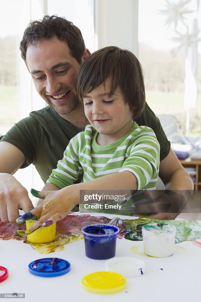 Father and son finger painting together