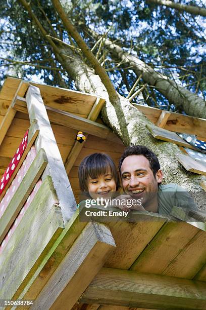 father and son playing in tree house - baumhaus stock-fotos und bilder
