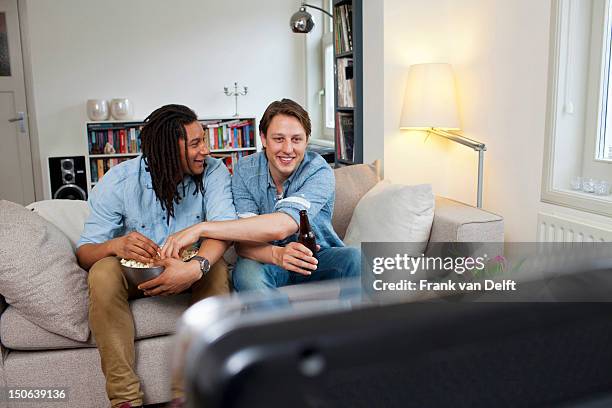 men watching television in living room - share house stock pictures, royalty-free photos & images